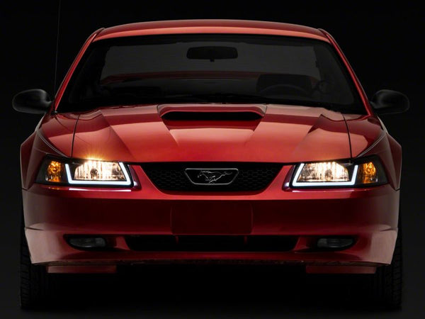 Raxiom 1999 - 2004 Ford Mustang Axial Series Headlights w/ LED Bar- Black Housing (Clear Lens)